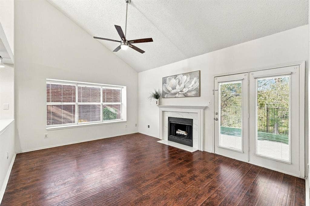 6821 Douglas Creek, Plano, TX 75023 Vaulted ceilings, wood-finish flooring, fireplace with a decorative surround, ceiling fan, and dual-pane glass doors