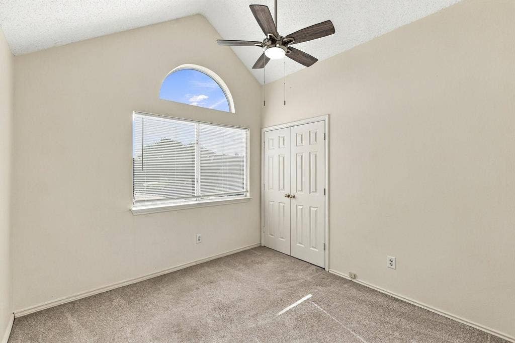 6821 Douglas Creek, Plano, TX 75023 Vaulted ceiling, arched window, neutral wall-to-wall carpeting, ceiling fan with light fixture, and double-door closet