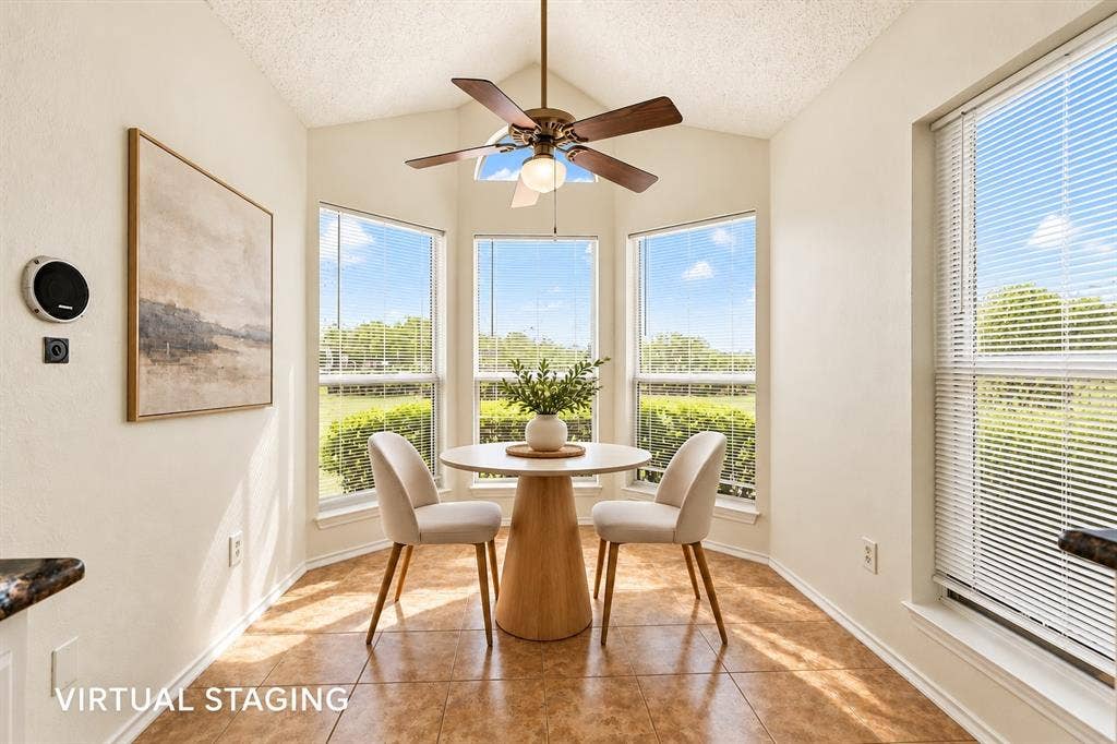 6821 Douglas Creek, Plano, TX 75023 Vaulted ceiling featuring a central blade-style ceiling fan, large windows with horizontal blinds, and ceramic tile flooring