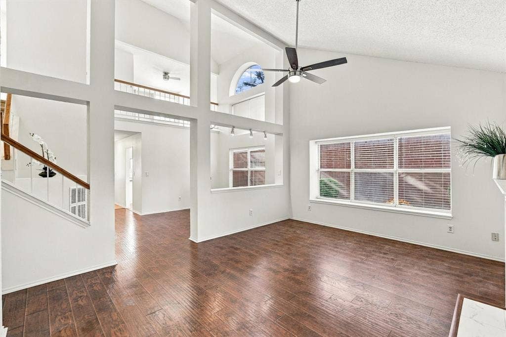 6821 Douglas Creek, Plano, TX 75023 Vaulted ceilings, wood-finish flooring, multi-level interior windows, staircase with wooden handrail, and integrated ceiling fan with lighting