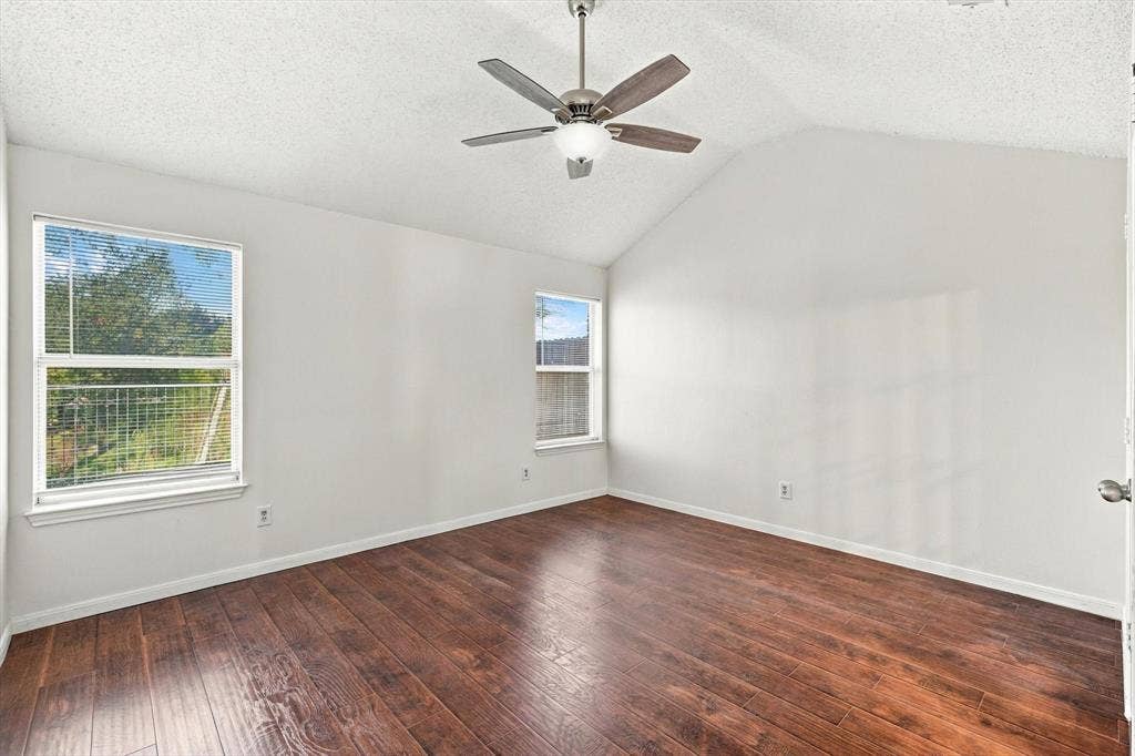 6821 Douglas Creek, Plano, TX 75023 Vaulted ceilings, wood-finish flooring, two dual-pane windows, and a ceiling fan with integrated lighting