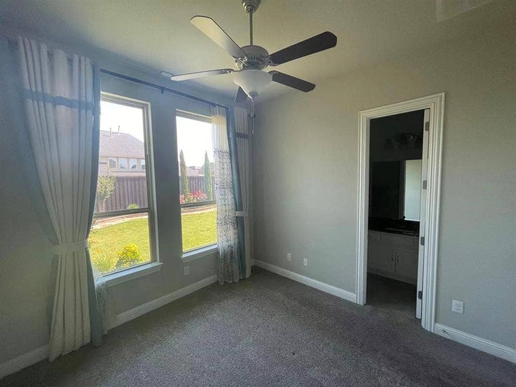 15112 Morning Star Lane, Frisco, TX 75035 Neutral-toned interior featuring dual windows, carpeted flooring, and a ceiling fan with integrated lighting