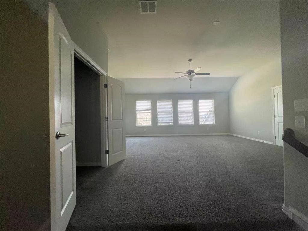 15112 Morning Star Lane, Frisco, TX 75035 Open-concept area featuring a vaulted ceiling, neutral carpeting, four large windows, and a ceiling fan