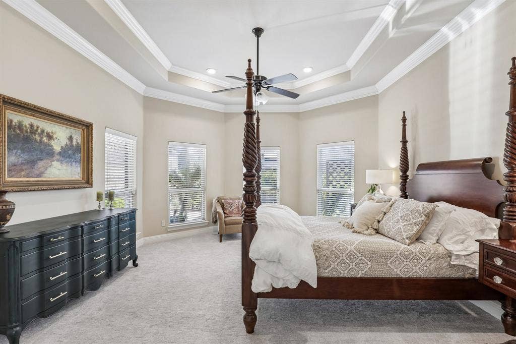 676 Princeton Way, Rockwall, TX 75087 Large primary bedroom with tray ceiling with crown molding, recessed lighting, central ceiling fan, and multiple windows