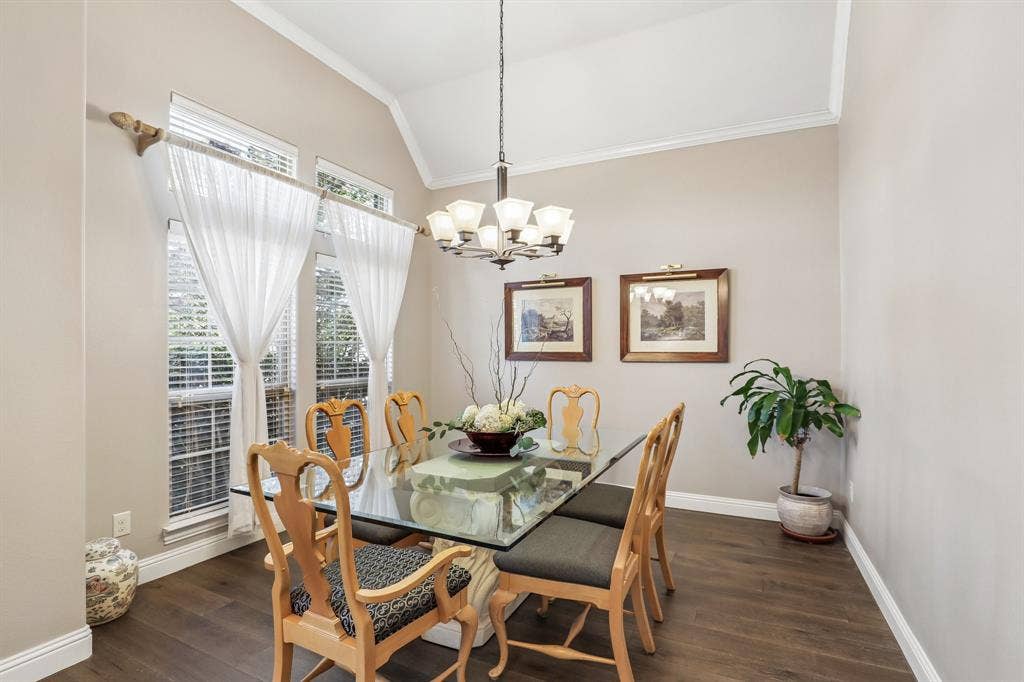 676 Princeton Way, Rockwall, TX 75087 Large dining room with vaulted ceiling with crown molding, wood-finish flooring, multi-pane windows, and a tiered chandelier