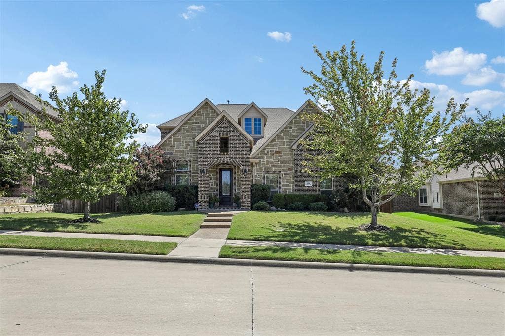 676 Princeton Way, Rockwall, TX 75087 Stone exterior featuring a multi-gabled roofline, central covered entryway, and mature landscaping