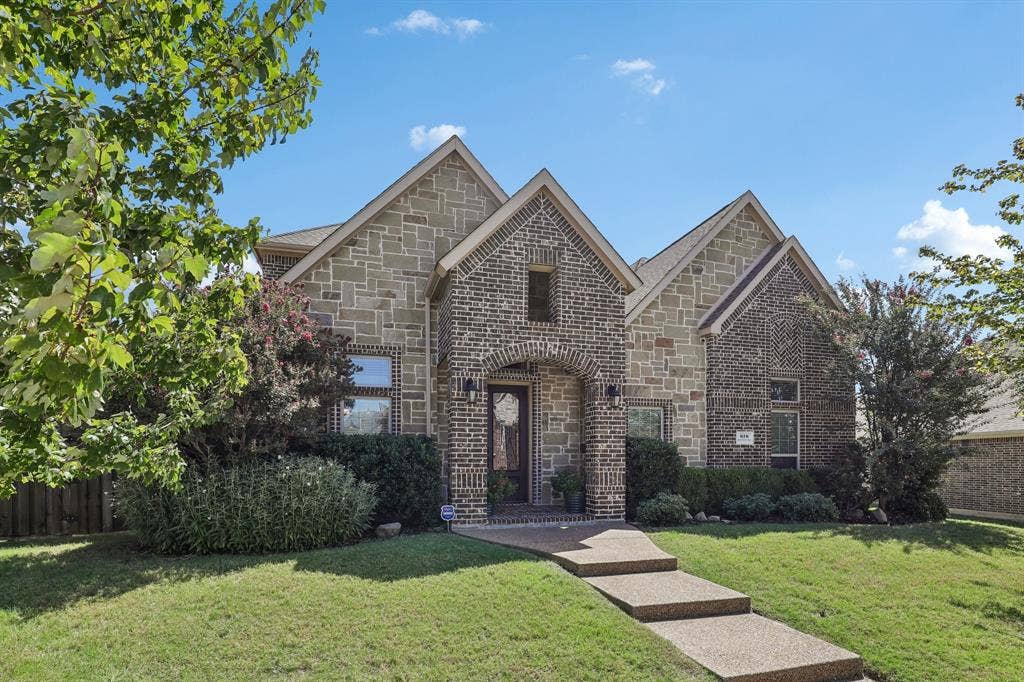 676 Princeton Way, Rockwall, TX 75087 Multi-gabled exterior featuring masonry facade, arched entryway with brick detailing, and paved walkway