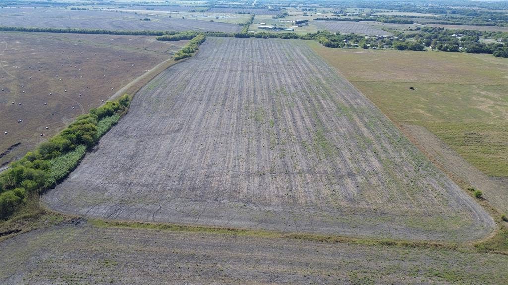 Expansive acreage featuring level topography, cleared open terrain, and mature perimeter tree lines