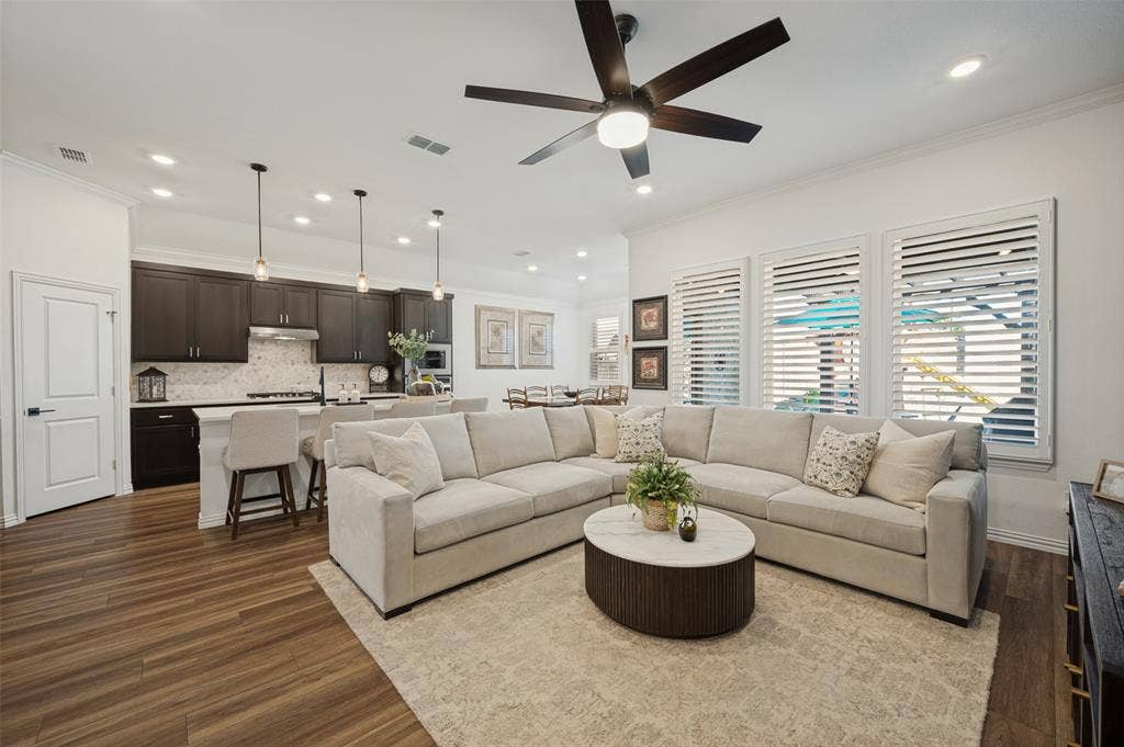 3417 Paintbrush Path, Melissa, TX 75454 Open-concept living space featuring wood-finish flooring, recessed lighting, and a kitchen equipped with dark cabinetry and a central island