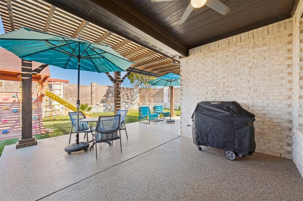 3417 Paintbrush Path, Melissa, TX 75454 Covered outdoor patio featuring a textured concrete floor, wooden pergola ceiling, white brick wall, and a ceiling-mounted fan