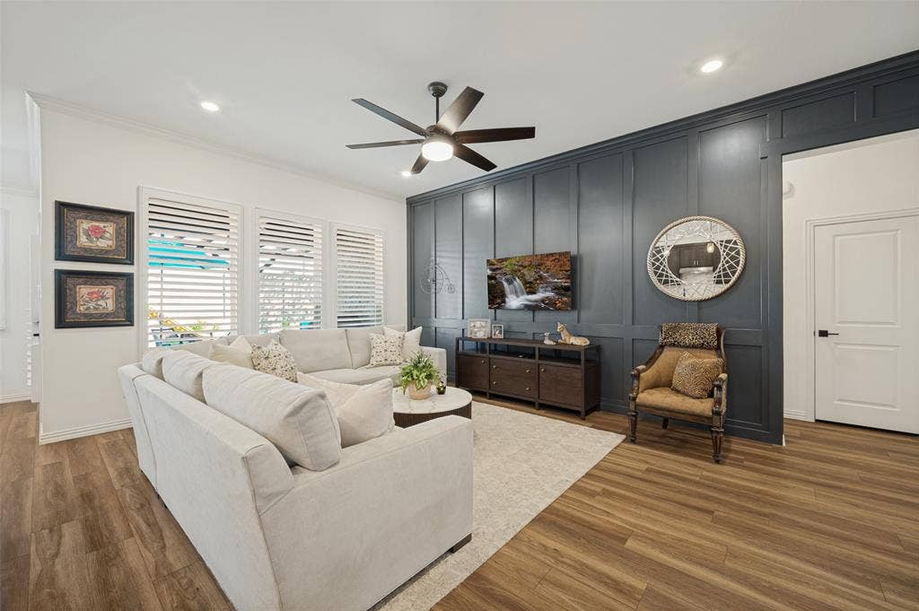 3417 Paintbrush Path, Melissa, TX 75454 Living area featuring a floor-to-ceiling dark-toned board and batten accent wall, wood-finish flooring, recessed lighting, and a modern multi-blade ceiling fan