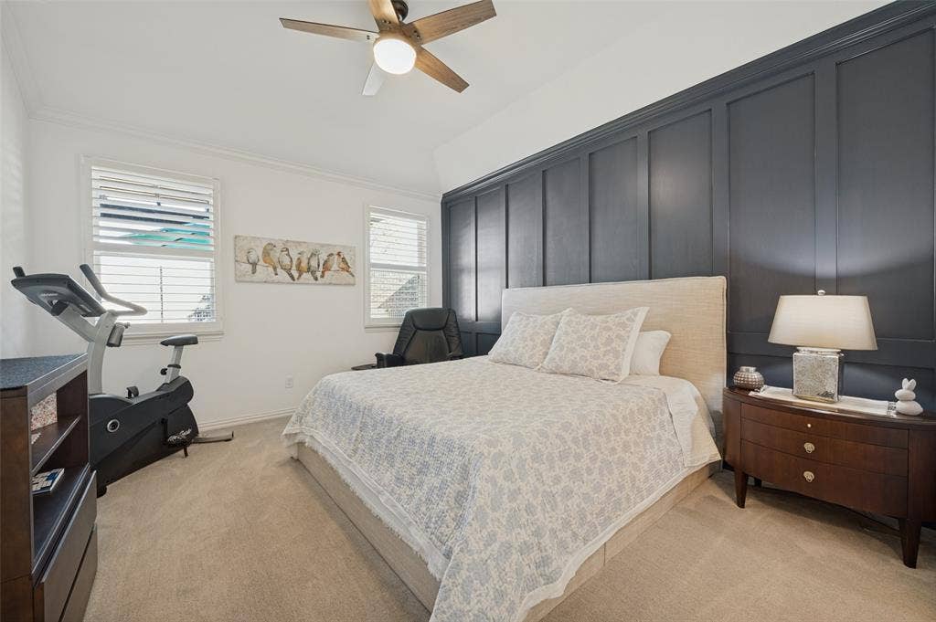3417 Paintbrush Path, Melissa, TX 75454 Room featuring floor-to-ceiling dark-toned paneling, wall-to-wall carpeting, dual windows with plantation shutters, and a ceiling fan with integrated lighting