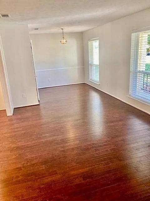 407 Cambridge Drive, Richardson, TX 75080 Wood-finish flooring, neutral wall tones, chair rail molding, multi-pane windows, and a suspended metal fixture