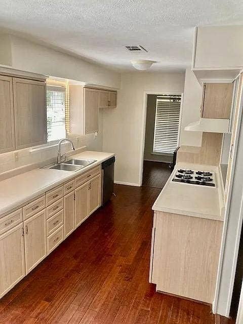407 Cambridge Drive, Richardson, TX 75080 Kitchen featuring light-finish cabinetry, wood-finish flooring, solid-surface countertops, a dual-basin stainless steel sink, and a built-in gas cooktop