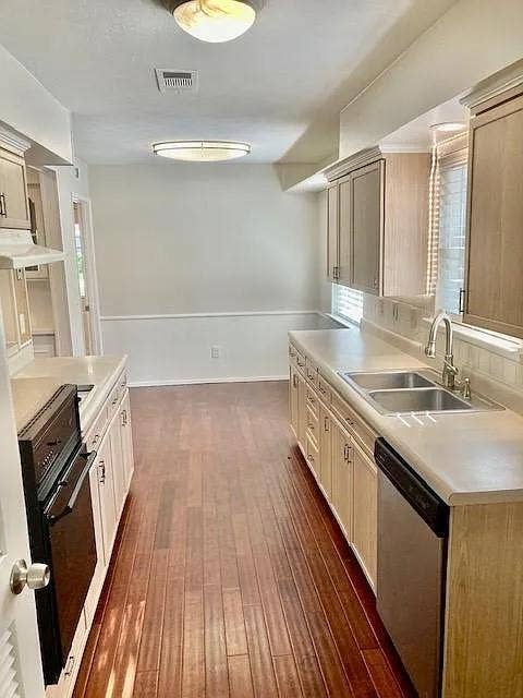 407 Cambridge Drive, Richardson, TX 75080 Kitchen featuring wood-finish flooring, light-toned cabinetry, dual-basin stainless steel sink, solid-surface countertops, and brushed nickel hardware
