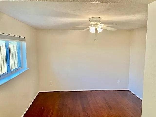 407 Cambridge Drive, Richardson, TX 75080 Room featuring wood-finish flooring, a white ceiling fan with integrated light fixture, and a window with a fixed sill