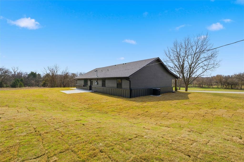 2303 Pilgrim Lane, Lorena, TX 76655 Exterior featuring dark-toned board-and-batten siding, horizontal lap siding, a paved concrete patio, and a shingled roof