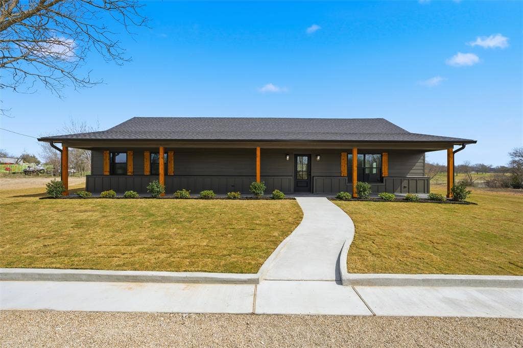 2303 Pilgrim Lane, Lorena, TX 76655 Single-story exterior featuring dark horizontal lap and vertical board-and-batten siding, a full-length covered porch with wood-finish posts, and a shingled roof