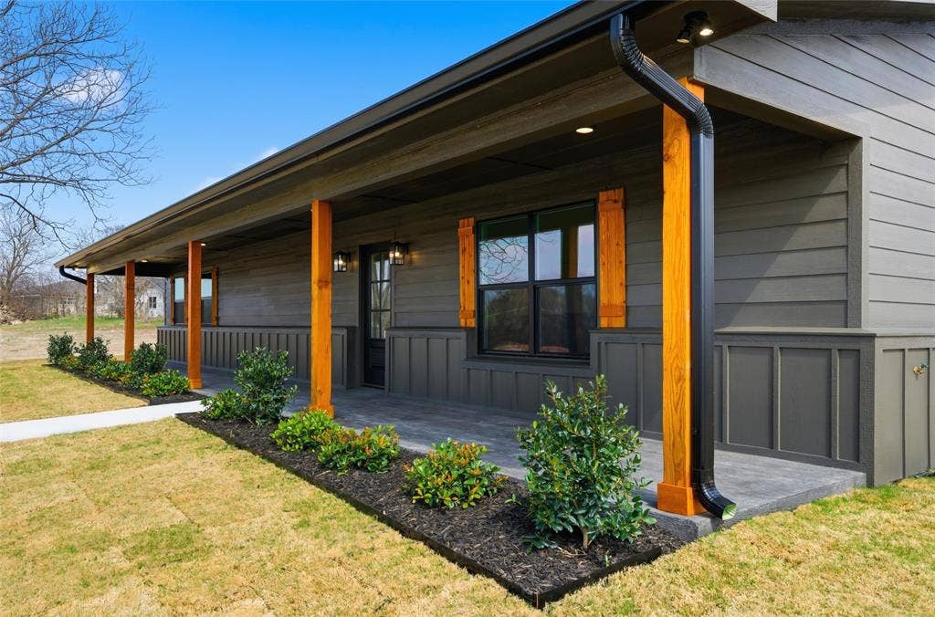 2303 Pilgrim Lane, Lorena, TX 76655 Exterior featuring board-and-batten and lap siding, a covered porch with natural wood support posts, dark-toned window shutters, and integrated recessed lighting