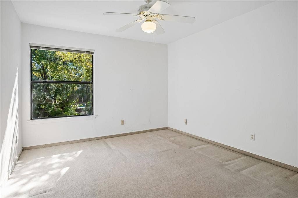 2926 N Saint Andrews Drive, Richardson, TX 75082 Bedroom #2 upstairs has a large closet with a built-in desk which was used as an office and also has a ceiling fan. Views of the backyard creek lot thru the window.