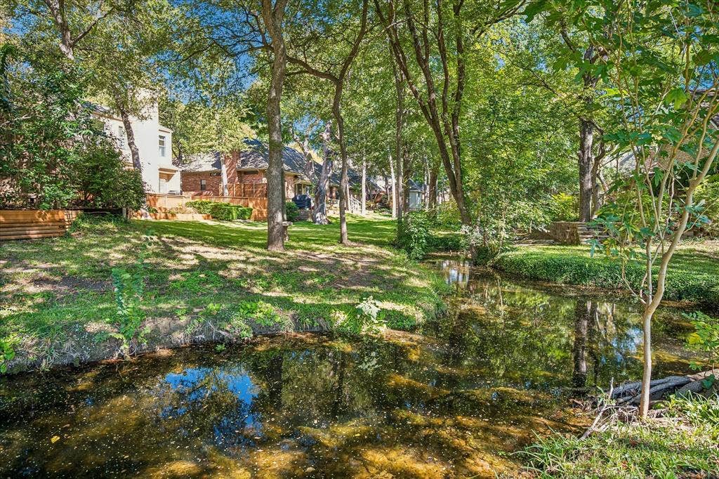 2926 N Saint Andrews Drive, Richardson, TX 75082 A view of the creek running through the neighborhood which is a view of the backyard of the property looking from the other side of the creek.