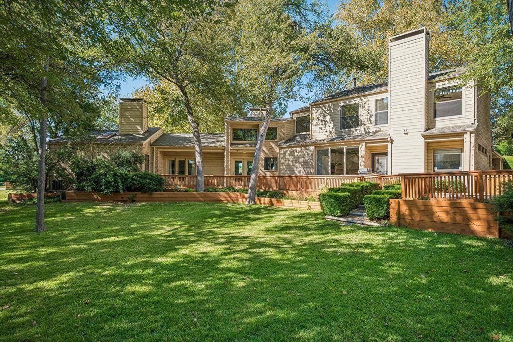 2926 N Saint Andrews Drive, Richardson, TX 75082 View of the back of the home with its unique architectural design and large wrap-around deck providing spectacular view of the large landscaped home and creek.