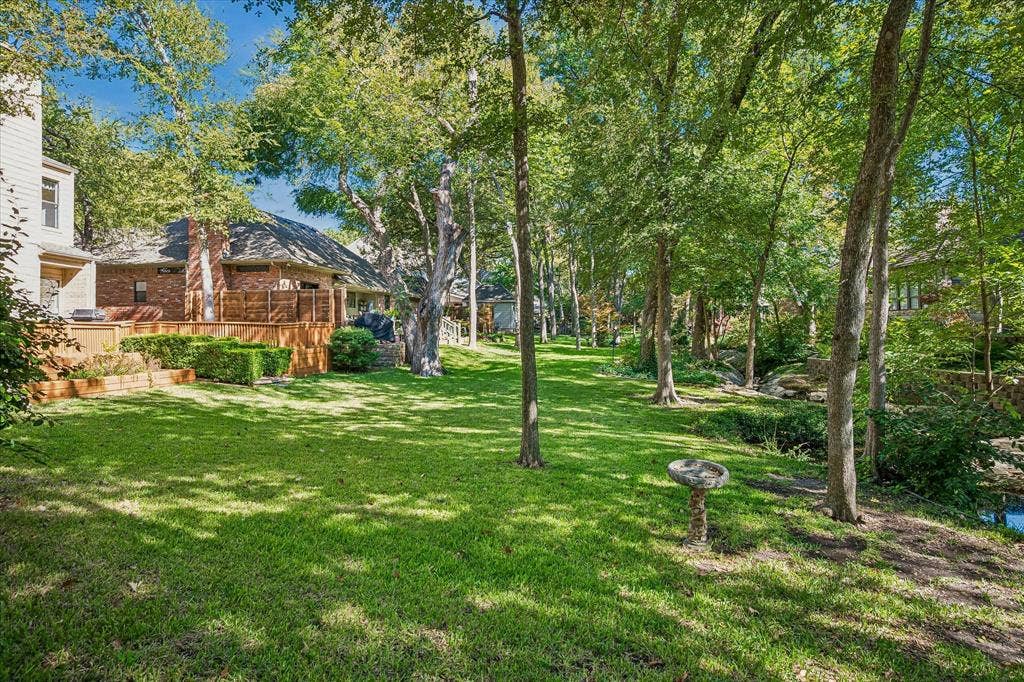 2926 N Saint Andrews Drive, Richardson, TX 75082 Another view of the backyard looking to the east of the home showing lots of trees and you can see the creek running across the backyard.