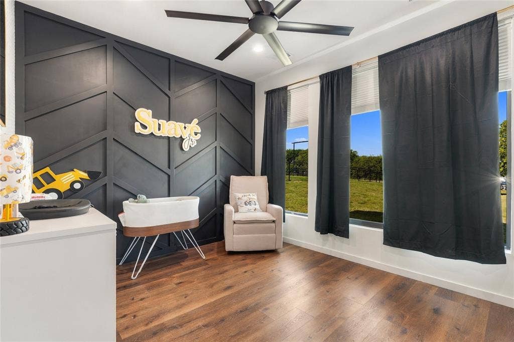 211 Hunter Pass, Waxahachie, TX 75165 Geometric wood accent wall in a dark matte finish, wood-finish flooring, and a modern ceiling fan