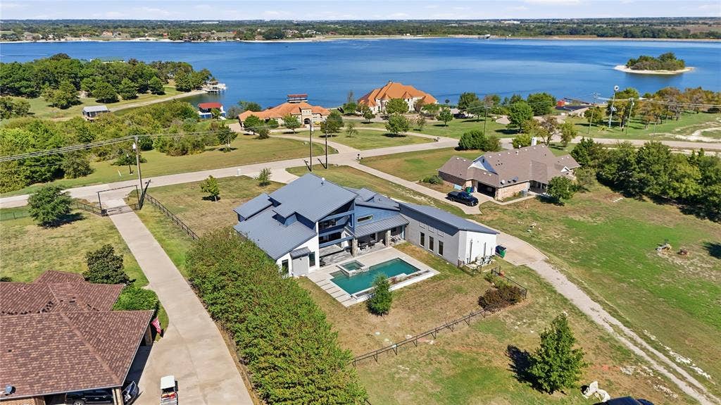 211 Hunter Pass, Waxahachie, TX 75165 Modern multi-level exterior with metal roofing, in-ground swimming pool, integrated spa, and expansive water frontage