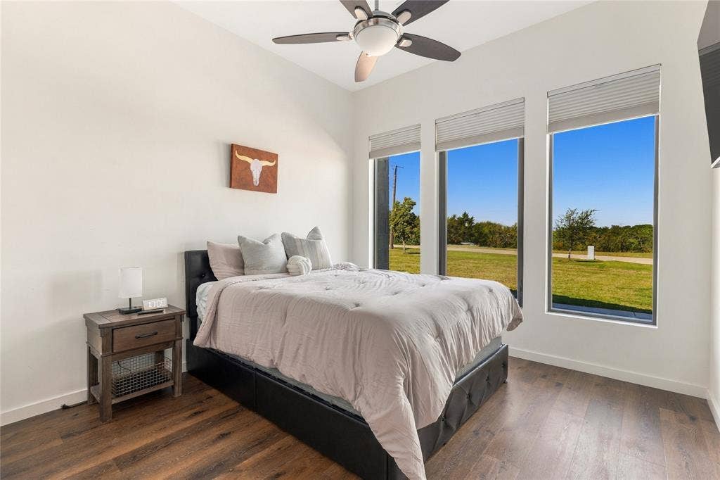 211 Hunter Pass, Waxahachie, TX 75165 High ceilings with a multi-blade ceiling fan, wood-finish flooring, and expansive windows featuring cellular shades