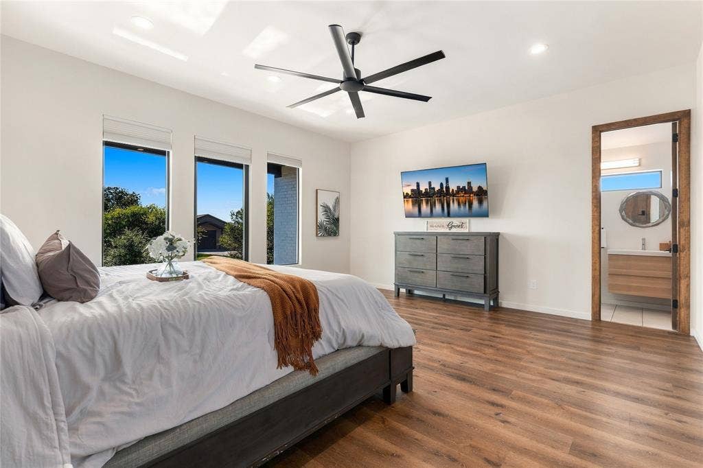 211 Hunter Pass, Waxahachie, TX 75165 Wood-finish flooring, recessed lighting, matte black ceiling fan, and large windows with roller shades