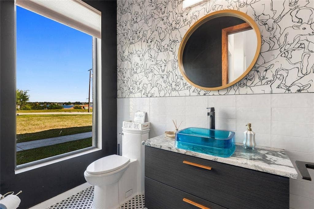 211 Hunter Pass, Waxahachie, TX 75165 Vanity featuring a dark wood-finish cabinet with horizontal hardware, a stone-patterned countertop, and a rectangular glass vessel sink with a matte black faucet