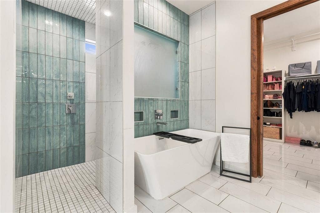 211 Hunter Pass, Waxahachie, TX 75165 Freestanding soaking tub, large-format vertical blue tile shower surround, mosaic tile shower flooring, and white polished tile flooring