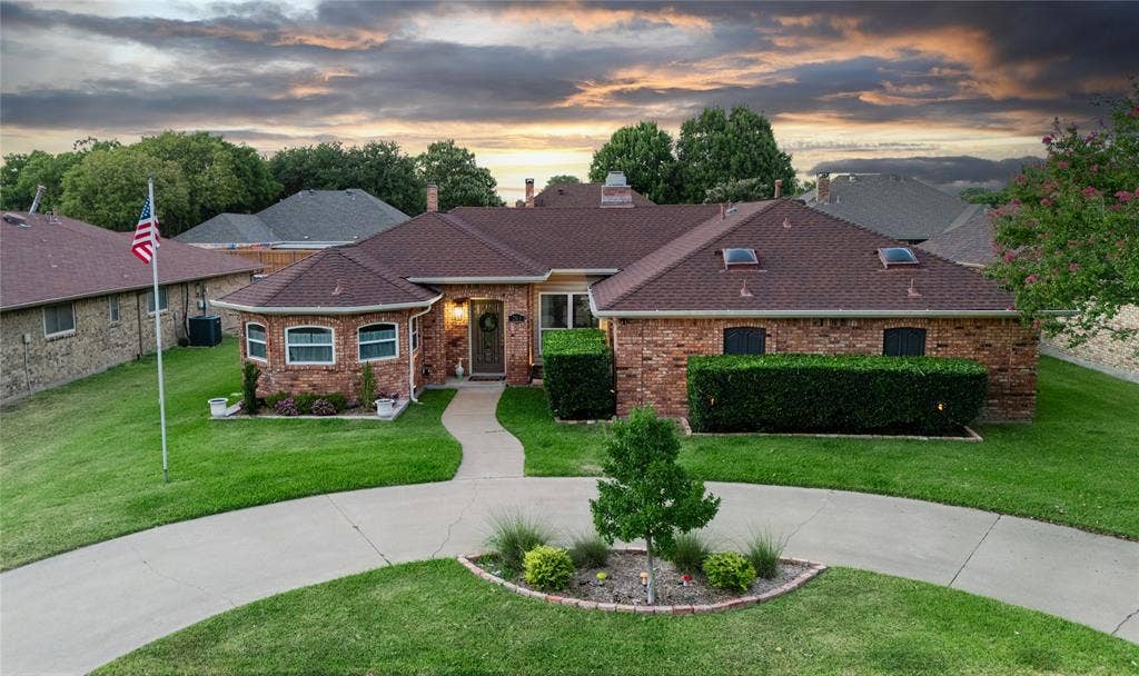 Brick exterior, mature landscaping, circular driveway, front walkway, skylights