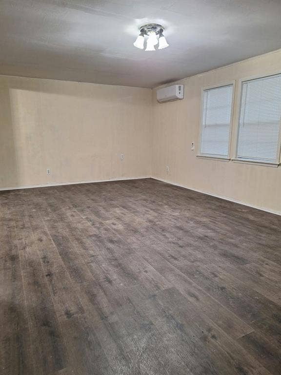 Wood-finish flooring, wall-mounted climate control unit, dual windows, and three-light ceiling fixture