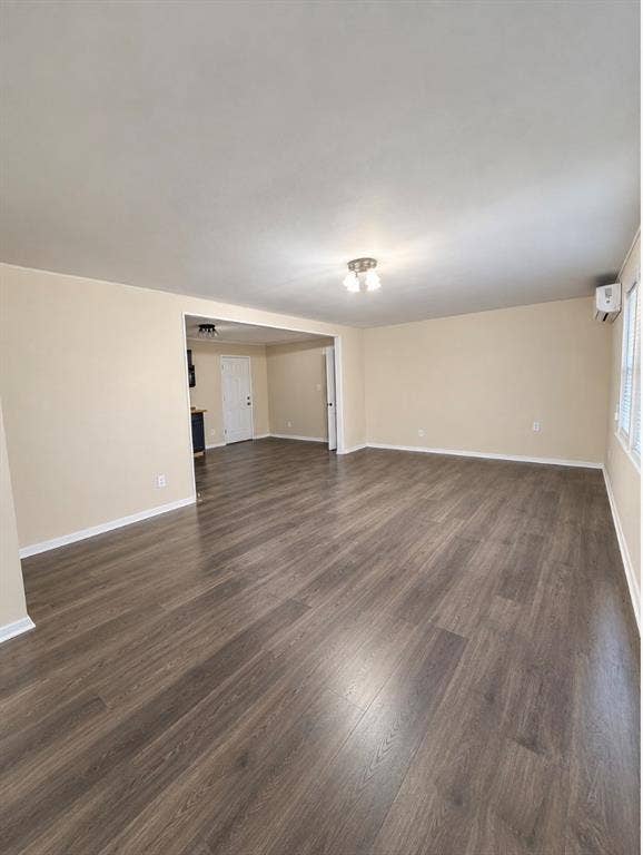 Open-concept area featuring wood-finish flooring, a wall-mounted ductless cooling unit, and central overhead lighting