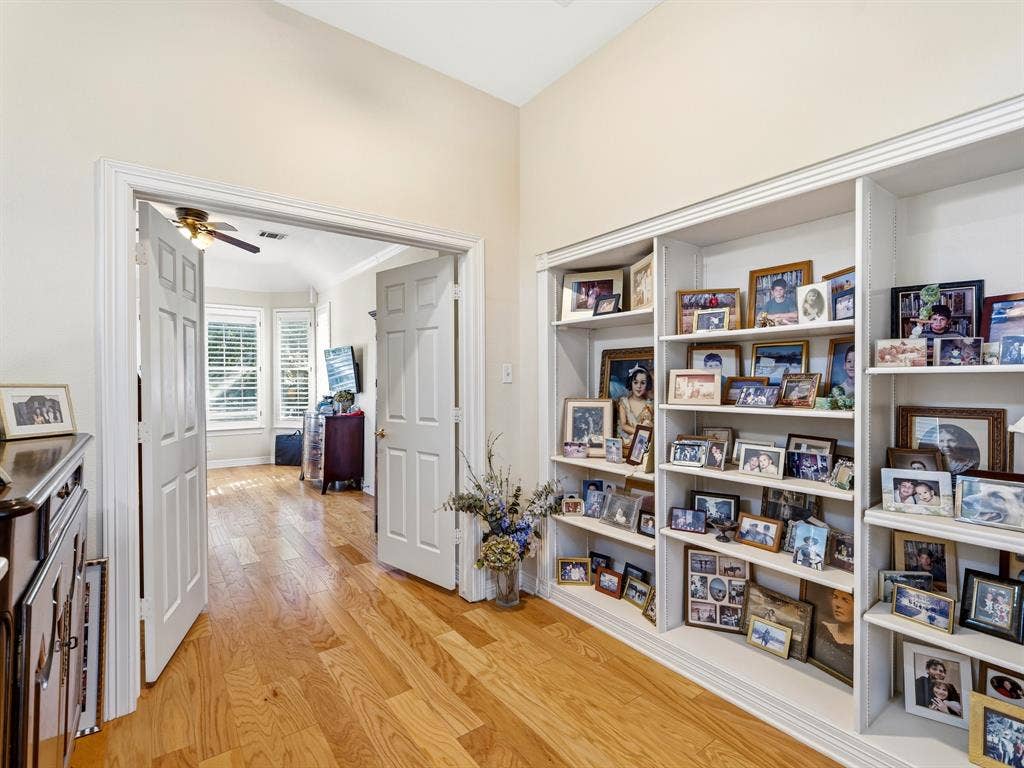14567 Juliard Lane, Addison, TX 75001 Built-in floor-to-ceiling shelving, wood-finish flooring, and arched double-door entry