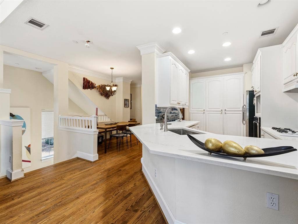 14567 Juliard Lane, Addison, TX 75001 Kitchen featuring white cabinetry, solid-surface countertops, wood-finish flooring, recessed lighting, and crown molding