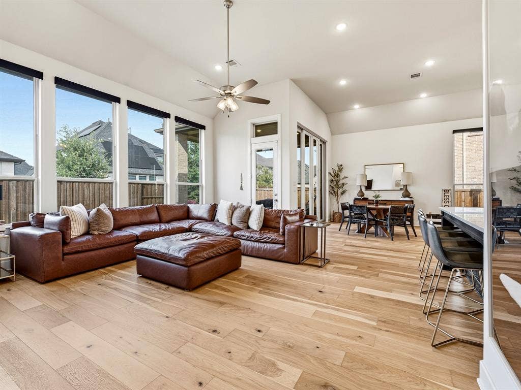 Vaulted ceilings, expansive floor-to-ceiling windows, recessed lighting, and wood-finish flooring