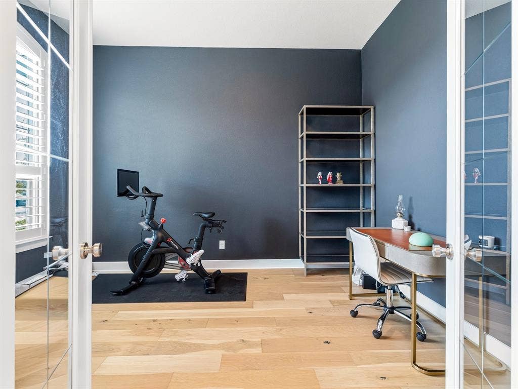 Room with wood-finish flooring, dark-toned walls, and French doors featuring glass panes