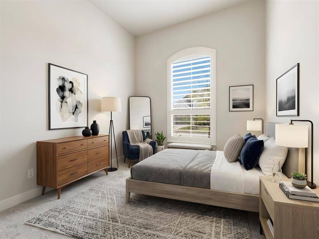 High-ceilinged room featuring an arched window, plantation shutters, and neutral wall-to-wall carpeting