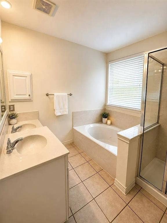 1207 Fox Trail Drive, Allen, TX 75002 Dual-sink vanity with a solid-surface countertop, jetted soaking tub, tiled shower enclosure with a glass door, and ceramic tile flooring