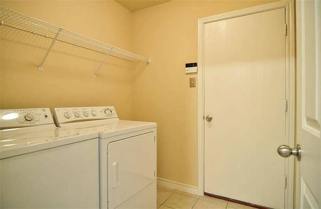 1207 Fox Trail Drive, Allen, TX 75002 Dedicated laundry space featuring tile flooring, a white interior door with metallic hardware, and white wire shelving