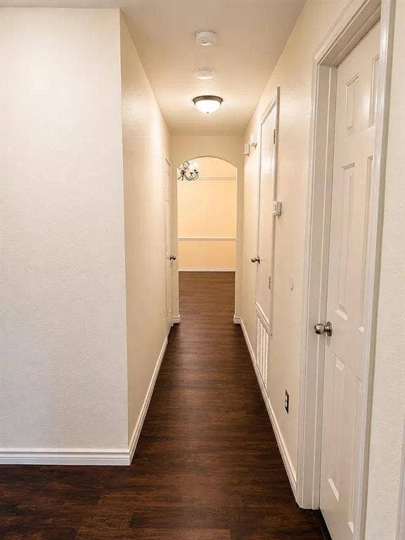 1207 Fox Trail Drive, Allen, TX 75002 Hallway featuring wood-finish flooring, white panel doors, recessed ceiling lighting, and an arched entry