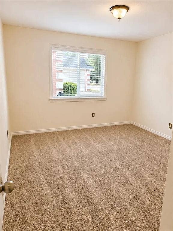 1207 Fox Trail Drive, Allen, TX 75002 Neutral-toned interior space featuring textured wall-to-wall carpeting, a single-pane window with horizontal blinds, and a semi-flush mount ceiling fixture