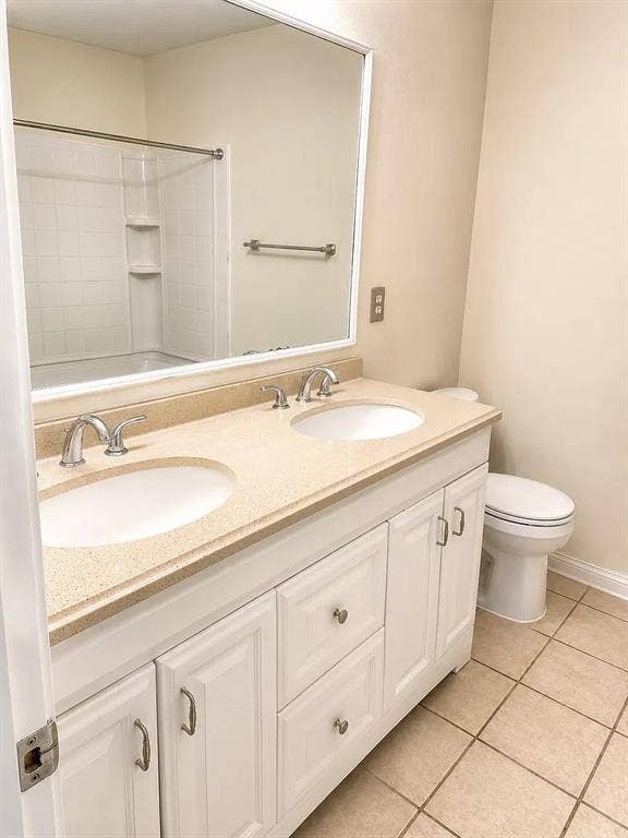 1207 Fox Trail Drive, Allen, TX 75002 Double vanity featuring white cabinetry, dual undermount sinks, solid surface countertop, large framed mirror, and tile flooring
