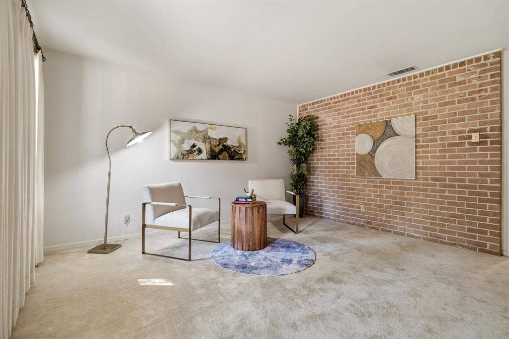 3209 Sheffield Street, Irving, TX 75062 Interior space featuring a floor-to-ceiling brick accent wall and neutral carpeting