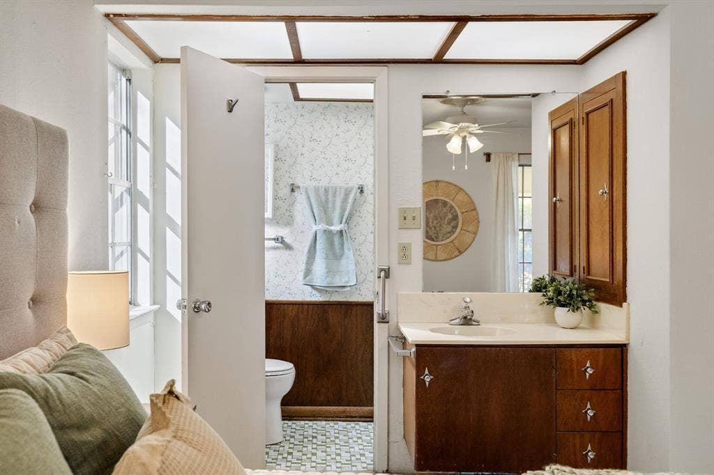 3209 Sheffield Street, Irving, TX 75062 Bathroom vanity featuring wooden cabinetry, integrated countertop with a recessed basin, and wall-mounted wooden medicine cabinet