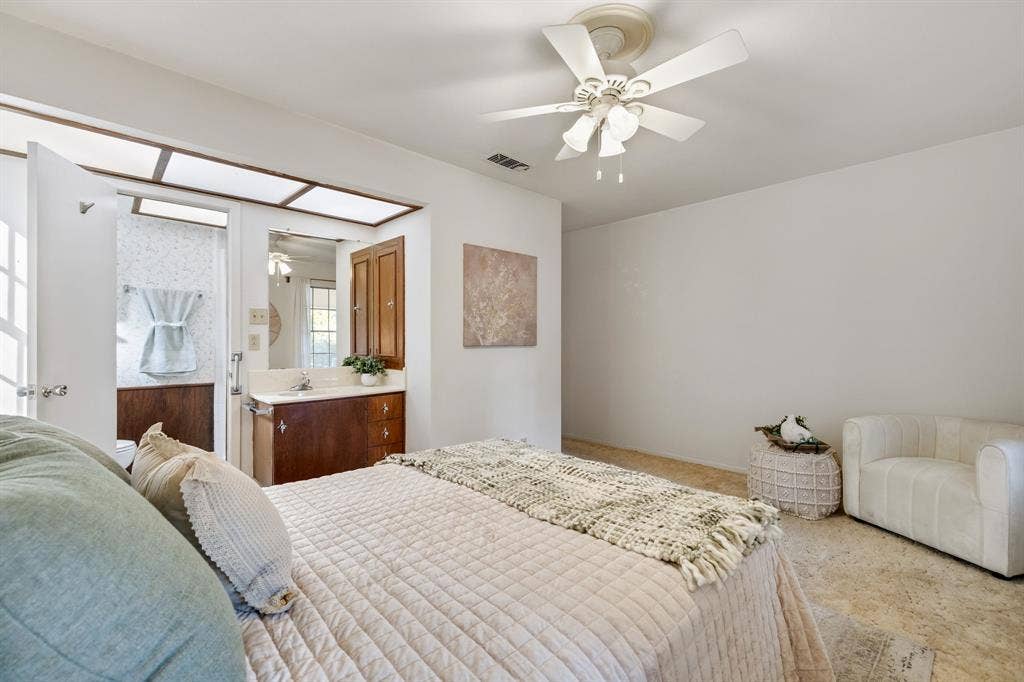 3209 Sheffield Street, Irving, TX 75062 Bedroom featuring a neutral color palette, ceiling fan with multi-light fixture, carpeted flooring, and a built-in vanity with wood-finish cabinetry