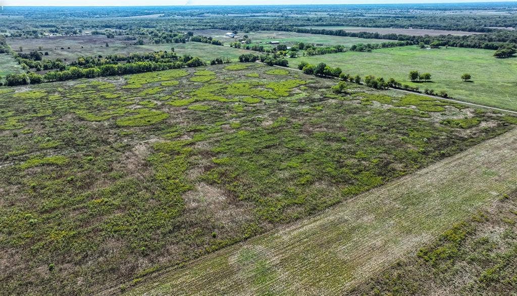 0 County Road 4604, Commerce, TX 75428 Expansive acreage featuring cleared pasture land, clusters of mature trees, and natural terrain boundaries